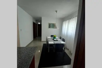 a dining room with a black and white table and chairs at Confortable apartamento de 3 tres habitaciones, con hermosa vista de area verde, ademas de piscinas y juegos infantiles en area recreativa in Santiago de los Caballeros