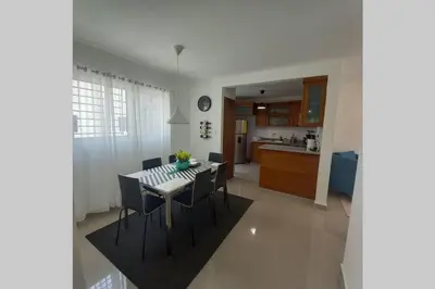 a kitchen and dining room with a table and chairs at Confortable apartamento de 3 tres habitaciones, con hermosa vista de area verde, ademas de piscinas y juegos infantiles en area recreativa in Santiago de los Caballeros