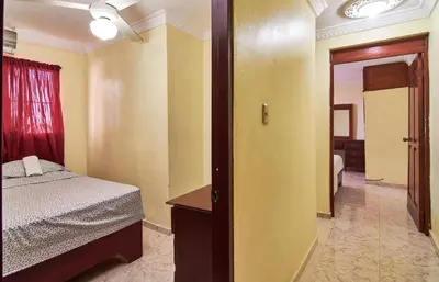 a bedroom with a bed and a door to a room at 2 Bedroom-Apartment - Corales del Sur Ole Las Americas- Isabelita - Aeropuerto in La Viva