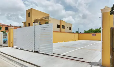 a gate in a parking lot in front of a building at 2 Bedroom-Apartment - Corales del Sur Ole Las Americas- Isabelita - Aeropuerto in La Viva