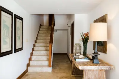 a hallway with stairs and a table with a lamp at Ocean View Villa/Luxury Puerto Bahia Resort/Samaná in Santa Bárbara de Samaná