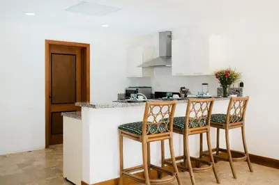 a kitchen with two chairs and a counter at Ocean View Villa/Luxury Puerto Bahia Resort/Samaná in Santa Bárbara de Samaná