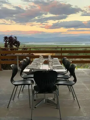a table with chairs and wine glasses on a patio at Altos de la Caobita in Barreras