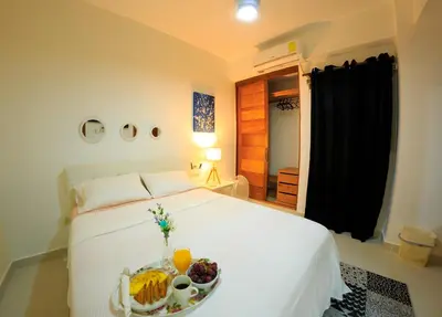 a bedroom with a bed with a tray of food on it at Self-checking-Fast internet-Alexa-Smart-Tv-AC-Hot Water in Ensanche Ozama