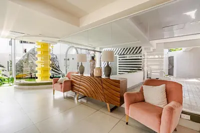 a living room with two chairs and a wooden cabinet at Cozy Apartment near Downtown Center in Santo Domingo
