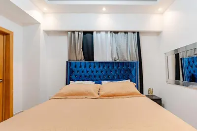 a bed with a blue headboard in a bedroom at Cozy Apartment near Downtown Center in Santo Domingo