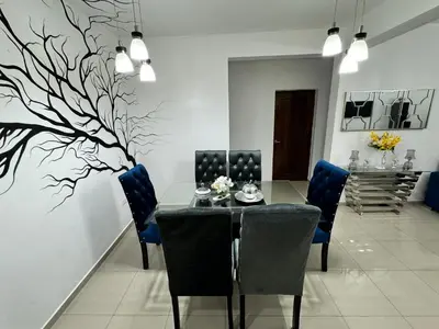 a dining room with a table and blue chairs at Paramount 3-Bedroom Apartment with Parking in San Felipe de Puerto Plata