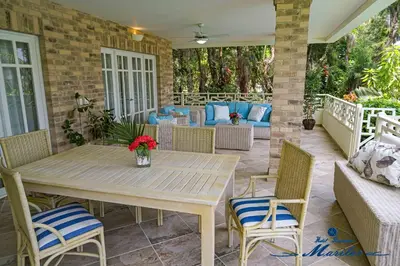 a patio with a wooden table and chairs at Hotel Residence Marilar in Las Terrenas