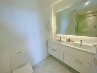 a white bathroom with a sink and a mirror at Cana Rock Star Pool View Whith BBQ in Punta Cana