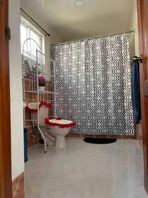 a bathroom with a toilet and a shower curtain at Entire Apartment Tu Nido De Amor netflix Wifi in Santo Domingo