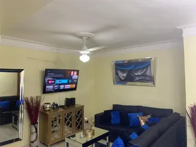 a living room with a blue couch and a tv at Entire Apartment Tu Nido De Amor netflix Wifi in Santo Domingo