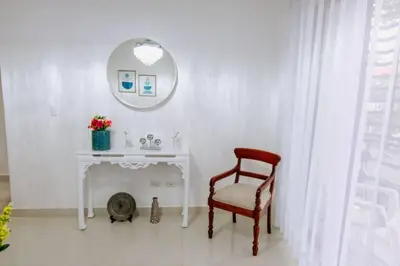 a bathroom with a white table and a chair and a mirror at Hermoso apartamento, 3 Habitaciones espaciosas, 2 Aires acondicionados in Santiago de los Caballeros