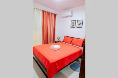 a bedroom with a red bed and red curtains at Hermoso apartamento, 3 Habitaciones espaciosas, 2 Aires acondicionados in Santiago de los Caballeros