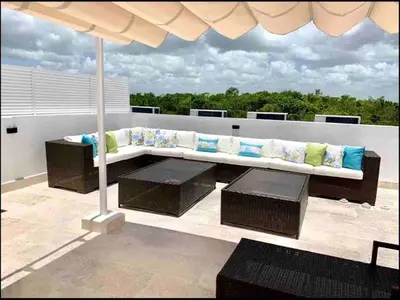 a bench with pillows and an umbrella on a roof at Cana Rock Chic Golf de Lux in Punta Cana