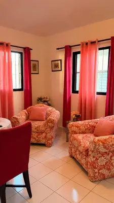 a living room with two couches and red curtains at Lovely location , right downtown Puerto Plata in San Felipe de Puerto Plata