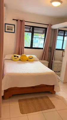 a bedroom with a bed with two yellow pillows on it at Lovely location , right downtown Puerto Plata in San Felipe de Puerto Plata