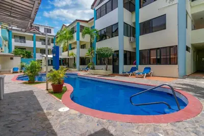 a swimming pool in front of a building at Apartamentos in Condo Plaza Europa in Sosúa