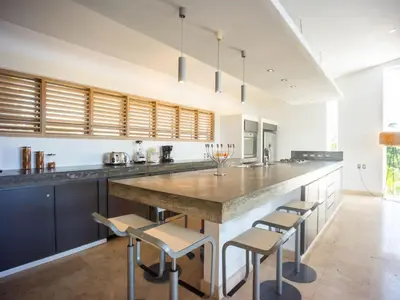 a kitchen with a large island with stools at Villas Agua Dulce in Sosúa