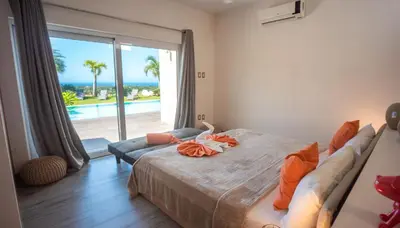 a bedroom with a bed and a view of the ocean at Villas Agua Dulce in Sosúa