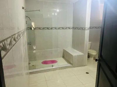a bathroom with a shower with a pink rug at Villa Luz in Baní