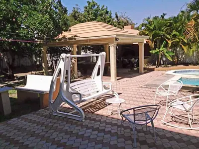 a slide and chairs next to a swimming pool at Villa Luz in Baní
