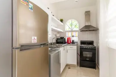 a kitchen with a refrigerator and a stove at Cozy 2 bdr condo, with pool area and free WIFI in Punta Cana