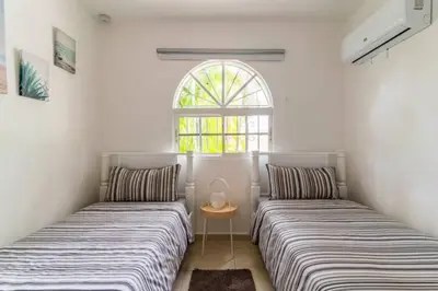 two beds in a room with a window at Cozy 2 bdr condo, with pool area and free WIFI in Punta Cana