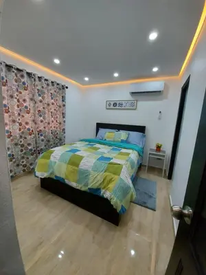 a bedroom with a bed with a colorful comforter at Cómodo Apto de 2hab con Aire 2baños, cerca de todo en Alma Rosa I in El Seis