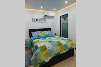 a bedroom with a bed with a yellow and blue comforter at Cómodo Apto de 2hab con Aire 2baños, cerca de todo en Alma Rosa I in El Seis