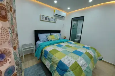 a bedroom with a bed with a colorful comforter at Cómodo Apto de 2hab con Aire 2baños, cerca de todo en Alma Rosa I in El Seis