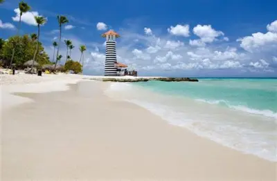 a beach with a lighthouse in the middle of the ocean at Casa en Paraiso RD in Bayahibe