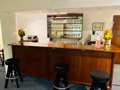 a bar with stools in a room with a counter at RIG Casa Conde in Santo Domingo