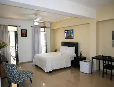 a bedroom with a white bed and a table and chairs at RIG Casa Conde in Santo Domingo
