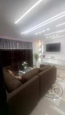 a living room with a brown couch and a television at SANTIAGO PARADISE 111 S 3 in Santiago de los Caballeros