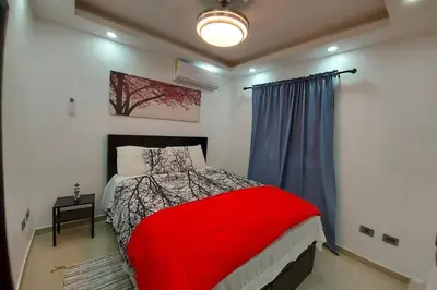 a bedroom with a bed with a red blanket at 4to nivel 2 habitaciones 2 baños Alma Rosa I in El Seis