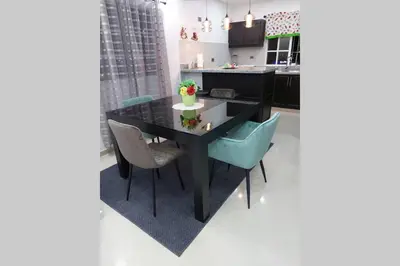 a kitchen with a black table and blue chairs at 4to nivel 2 habitaciones 2 baños Alma Rosa I in El Seis