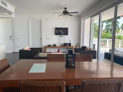 a dining room with a table and a living room at Spectacular Ocean View Spacious 2-Bedroom Condo, Vista Mare, Samana DR in Santa Bárbara de Samaná