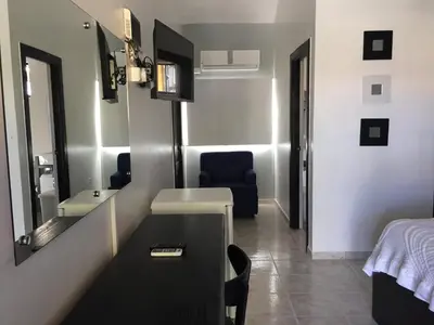 a small room with a table and a mirror at Hotel Las Caobas in San Francisco de Macorís