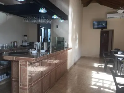 a bar in a room with a table and chairs at Hotel Santander SD in Santo Domingo