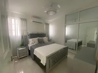 a bedroom with a large bed and a large window at 7DR Apt in Prime Location Near Monumental Area in Santiago de los Caballeros
