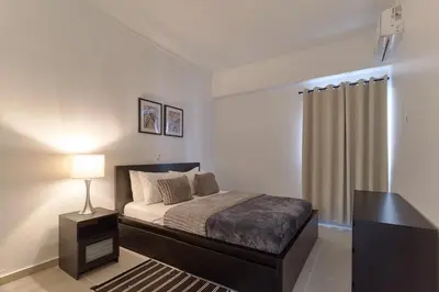 a bedroom with a bed with a lamp and a curtain at Dom. Rep. Exclusive 2 bed Apt. Evaristo Morales in Santo Domingo