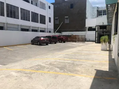 a parking lot with two trucks parked in front of a building at Hotel Señorial in Santo Domingo