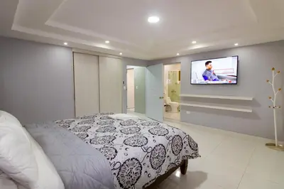 a bedroom with a bed and a tv on a wall at Hotel Señorial in Santo Domingo