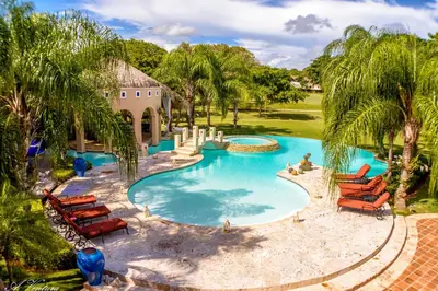 an overhead view of a pool with chairs and palm trees at Casa de Campo Luxury Villas - Private Paradise at La Romana in La Romana
