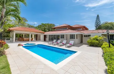 a swimming pool in front of a house at Casa de Campo Luxury Villas - Private Paradise at La Romana in La Romana