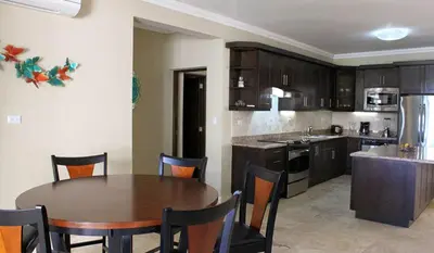 a kitchen with a wooden table and a dining room at Cozy and Luxurious 2 bedroom apartment in Sosúa