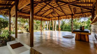 an open pavilion with a wooden floor and a table at Kibayo Lagoon Villa in Cabarete