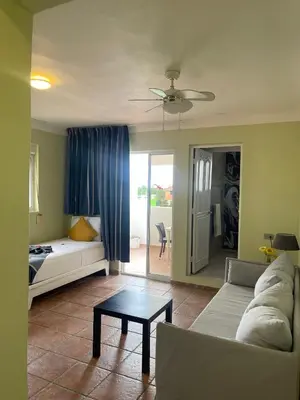 a living room with a couch and a bed and a table at Villa Iguana in Bayahibe