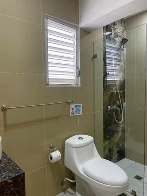 a bathroom with a toilet and a glass shower at Villa Iguana in Bayahibe