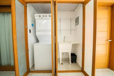 a small bathroom with a sink and a washer and dryer at S1404 Vista espectacular Downtown Santo Domingo in Santo Domingo